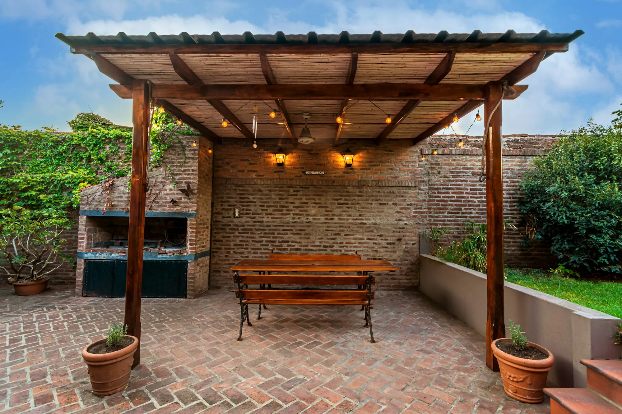 Brick patio under a wooden pergola with a picnic table