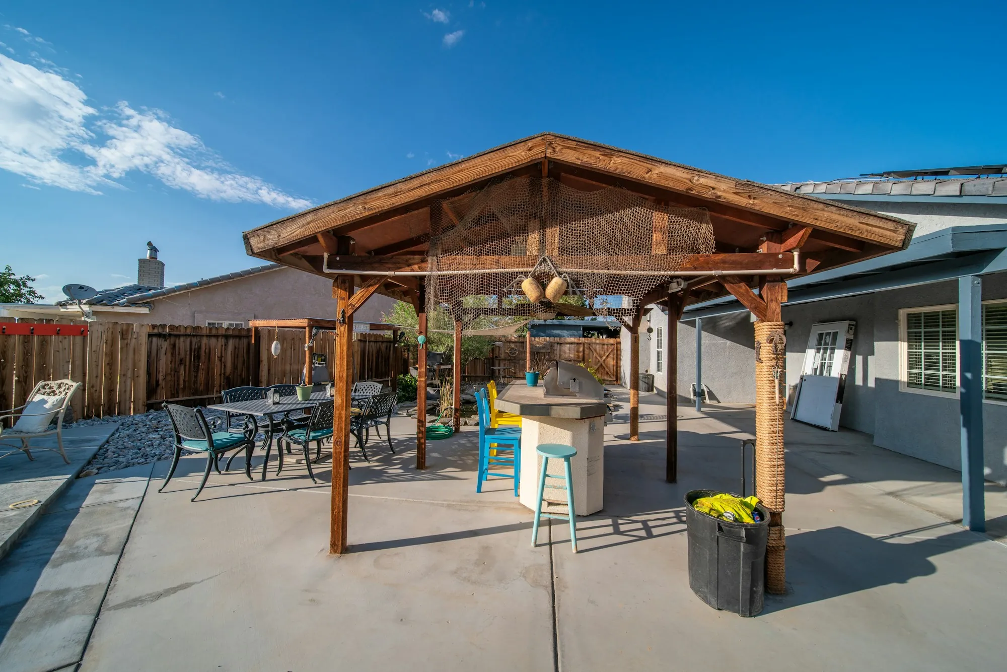Wood pavilion over a concrete patio with a dining set