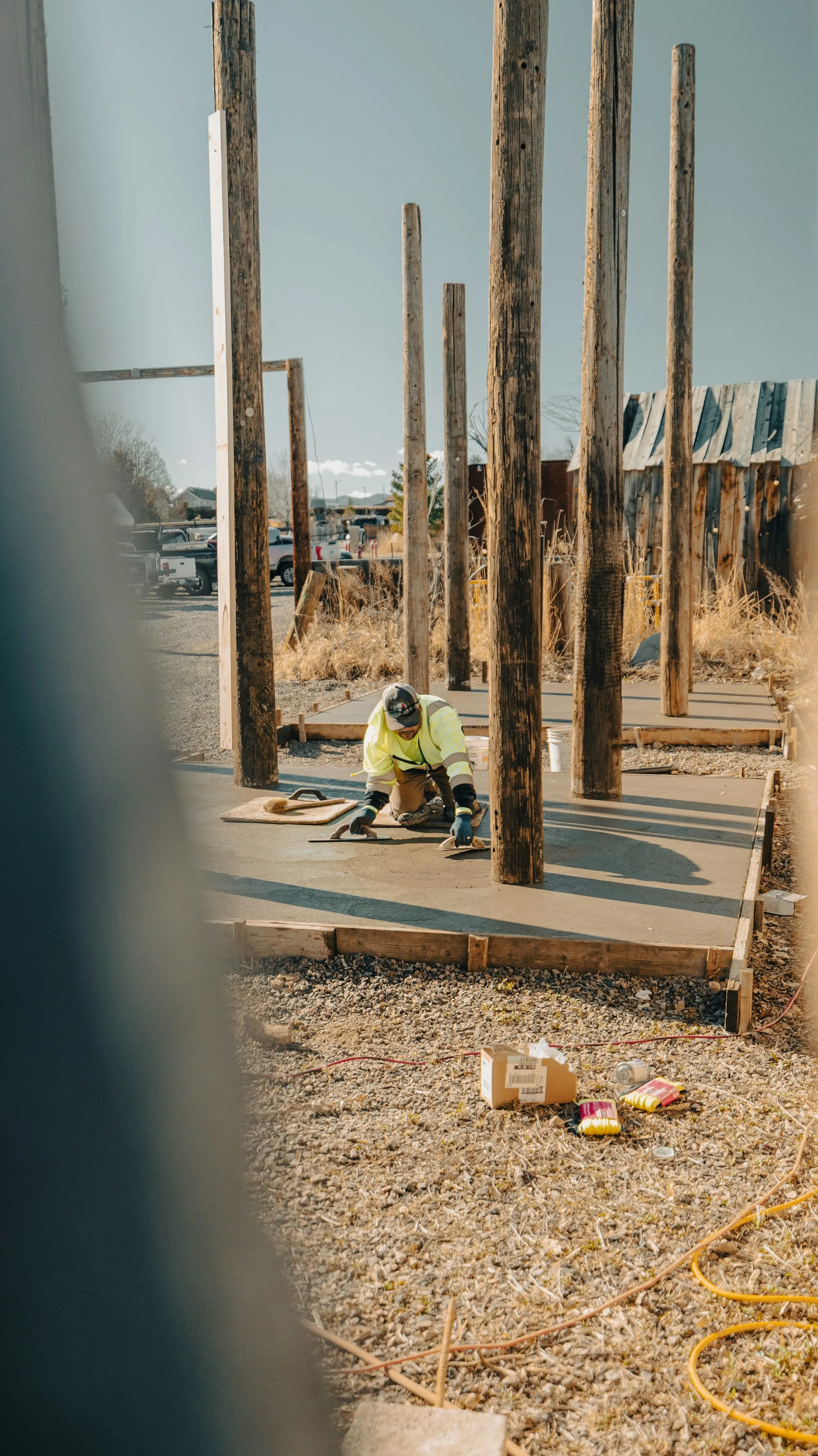 Worker finishing a concrete slab inside wood forms